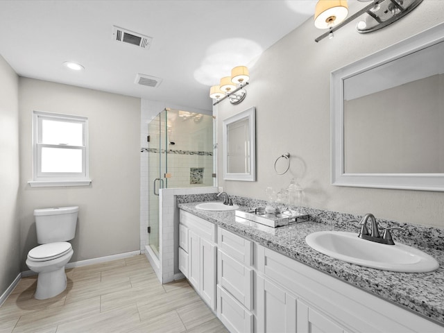 bathroom featuring a shower stall, toilet, visible vents, and a sink