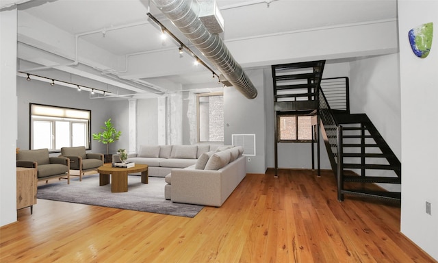 living room with stairway, track lighting, visible vents, and wood finished floors