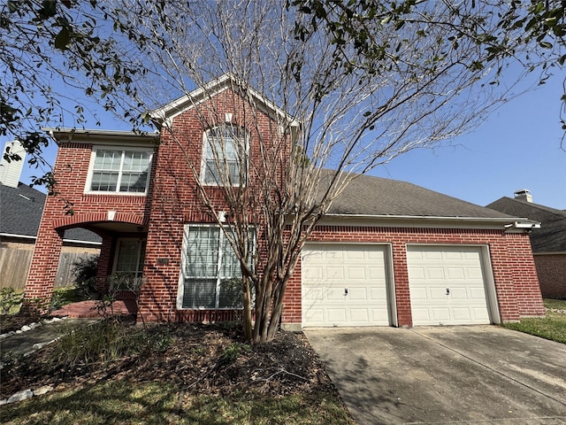 traditional home featuring driveway, brick siding, and an attached garage