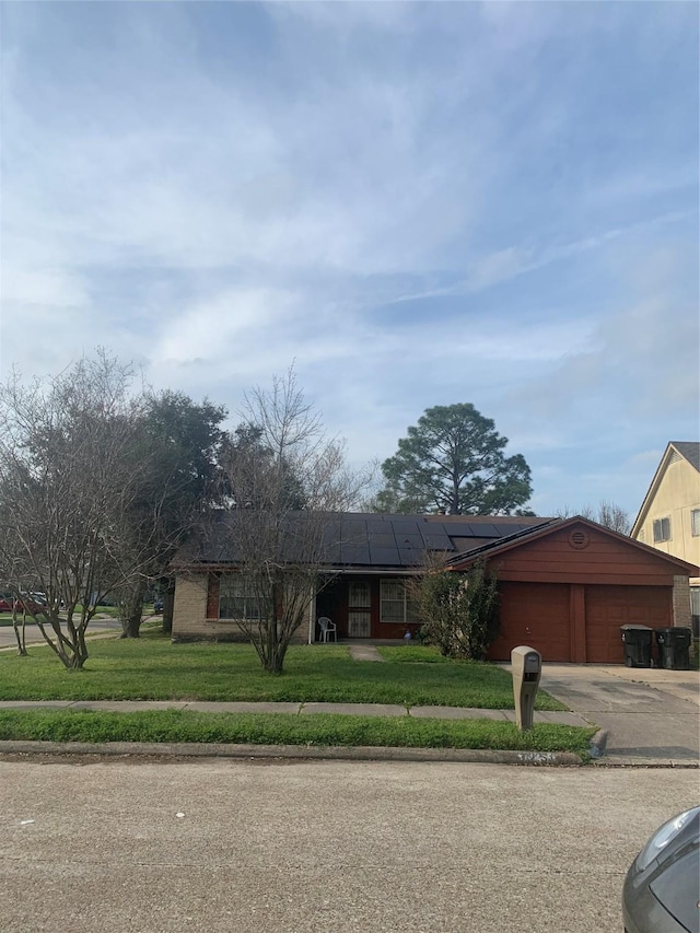 view of front of property featuring a garage, driveway, and a front lawn