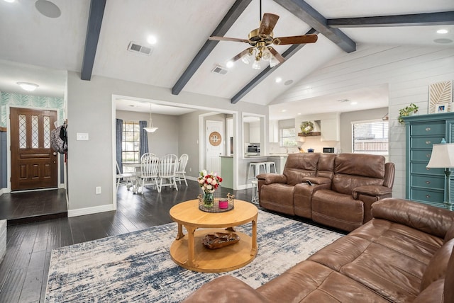 living room with vaulted ceiling with beams, visible vents, dark wood finished floors, and baseboards