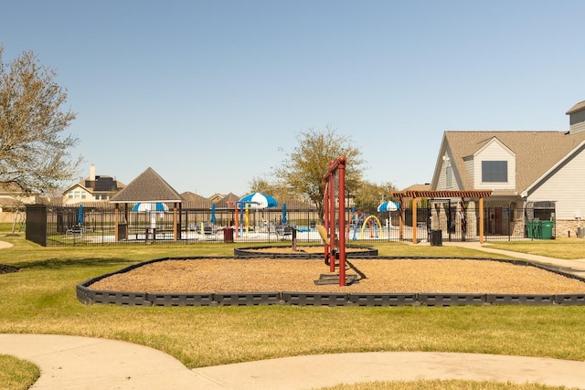 communal playground featuring a yard and fence