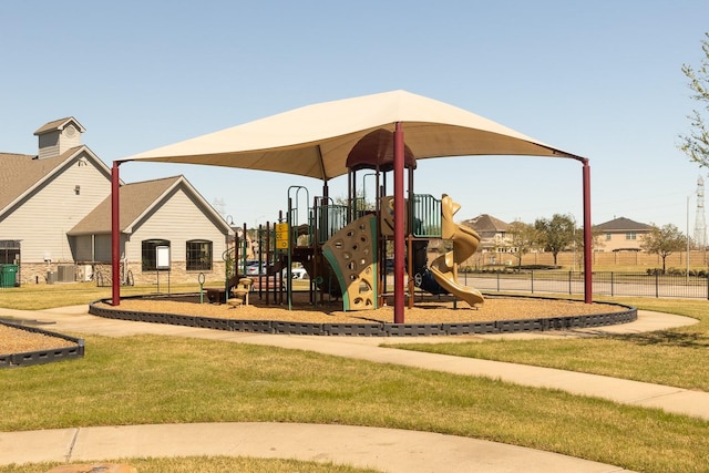 community jungle gym featuring central air condition unit and a lawn