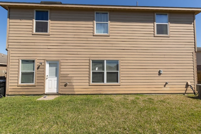 rear view of house featuring a yard