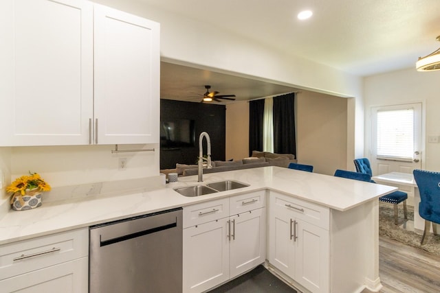 kitchen with a ceiling fan, a sink, stainless steel dishwasher, white cabinetry, and light stone countertops