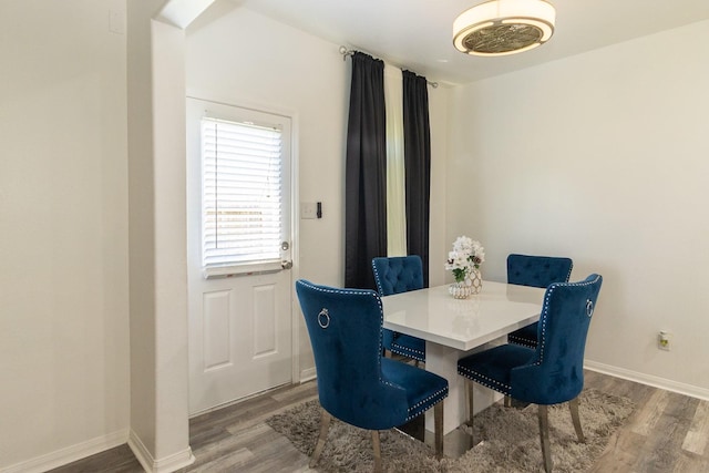 dining space with baseboards and wood finished floors