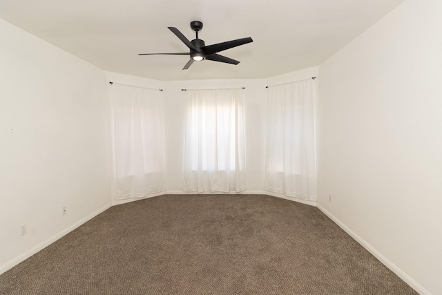 carpeted empty room with a ceiling fan and baseboards