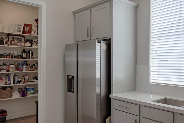 kitchen with light countertops and stainless steel refrigerator with ice dispenser