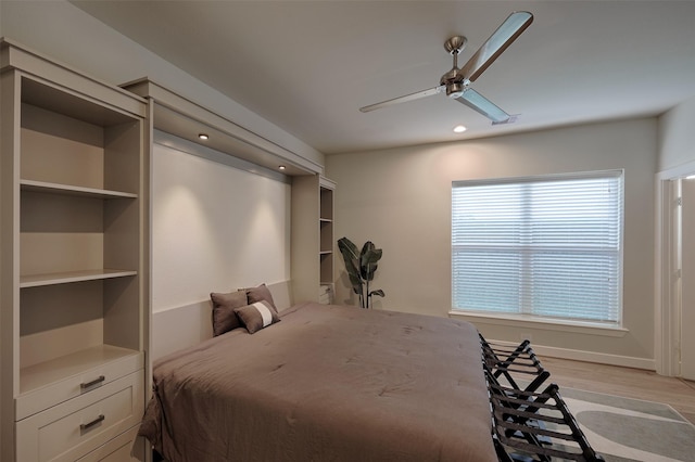 bedroom with ceiling fan, light wood-type flooring, and baseboards