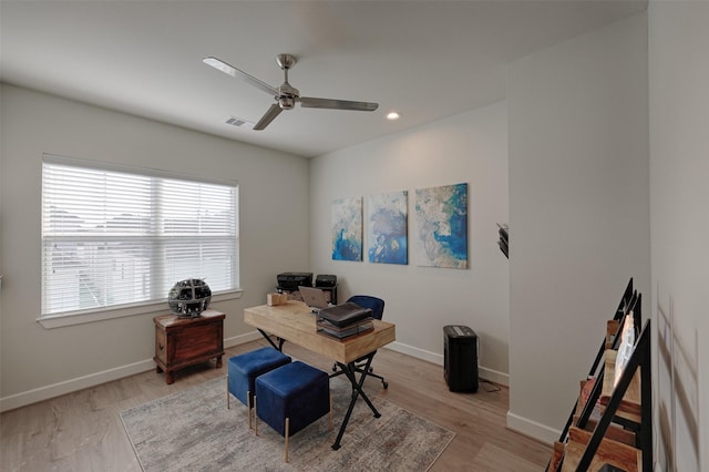 home office with ceiling fan, light wood-type flooring, visible vents, and baseboards