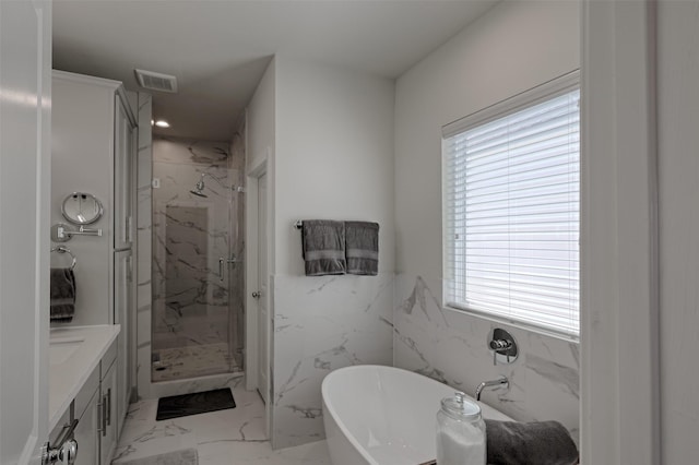 full bathroom with marble finish floor, a marble finish shower, visible vents, a freestanding bath, and vanity