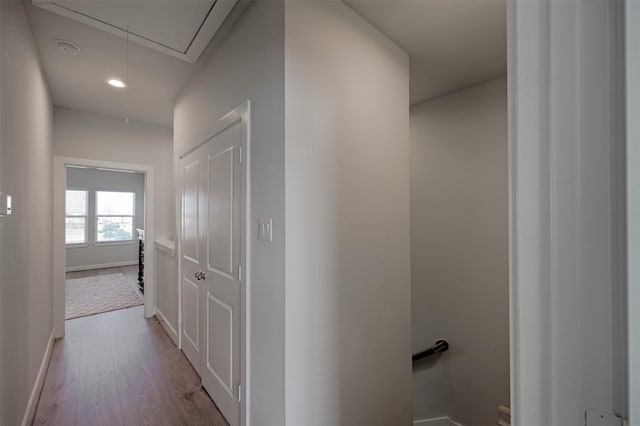 hallway featuring recessed lighting, wood finished floors, an upstairs landing, baseboards, and attic access