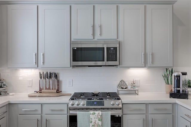 kitchen featuring appliances with stainless steel finishes, light countertops, and backsplash