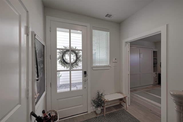 entryway with light wood-style floors and visible vents