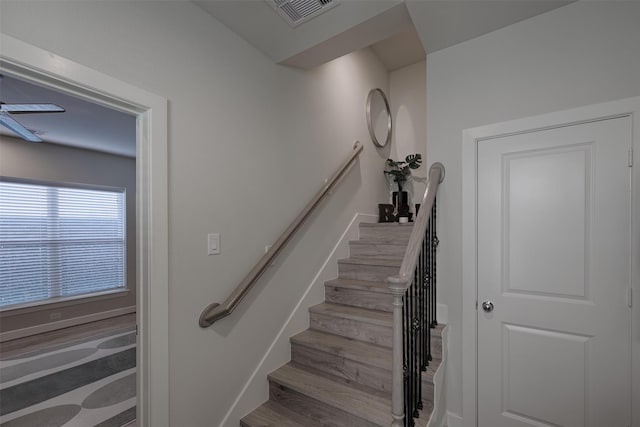 staircase with visible vents, ceiling fan, baseboards, and wood finished floors