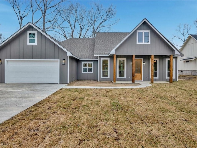 view of front of house featuring covered porch, a shingled roof, driveway, a front lawn, and board and batten siding