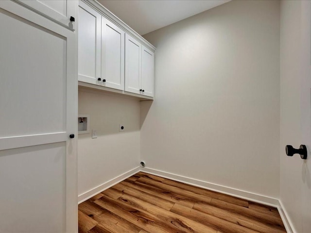 laundry room featuring cabinet space, baseboards, electric dryer hookup, and wood finished floors