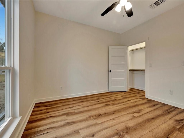 unfurnished bedroom featuring a ceiling fan, visible vents, baseboards, a closet, and light wood finished floors