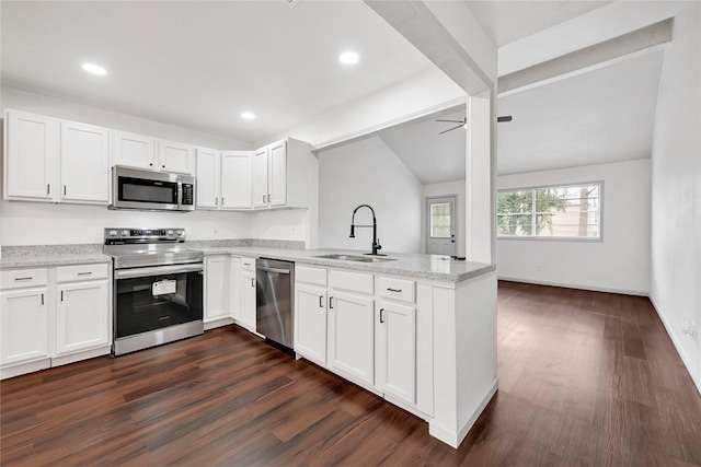 kitchen featuring appliances with stainless steel finishes, white cabinetry, a sink, and a peninsula