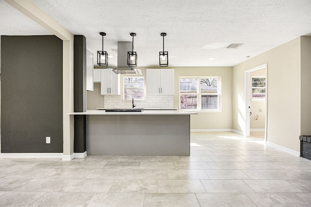 kitchen featuring visible vents, decorative backsplash, white cabinets, hanging light fixtures, and light countertops