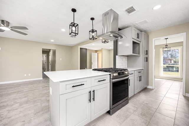 kitchen with island exhaust hood, light countertops, stainless steel range with gas cooktop, and visible vents