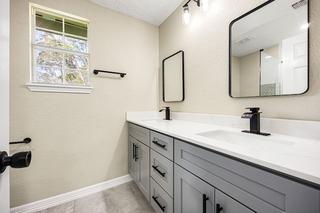 full bathroom featuring visible vents, a sink, a textured ceiling, and double vanity