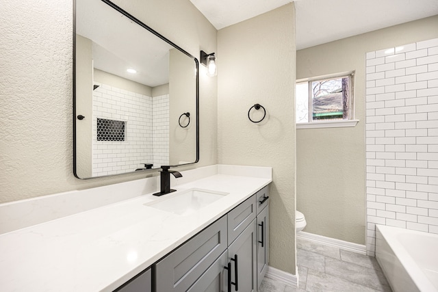 full bath featuring a textured wall, toilet, vanity, and baseboards