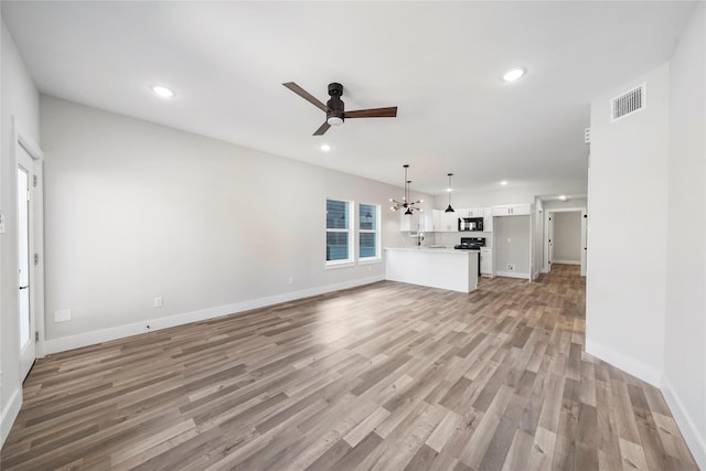 unfurnished living room featuring light wood-style flooring, recessed lighting, a ceiling fan, baseboards, and visible vents