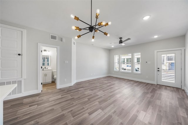 unfurnished living room with light wood-style floors, visible vents, and baseboards