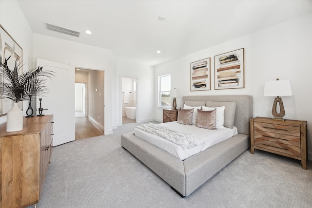 bedroom with recessed lighting, light colored carpet, visible vents, ensuite bathroom, and baseboards