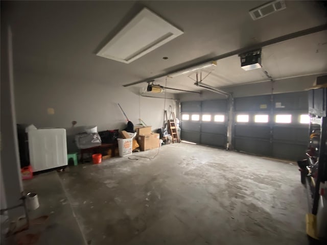 garage featuring a garage door opener and visible vents