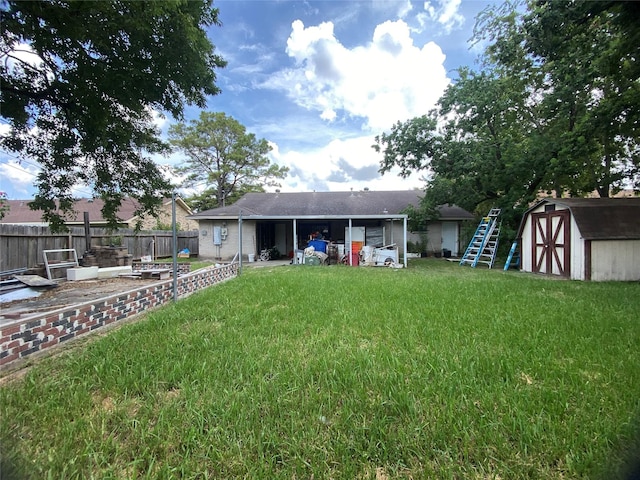 view of yard with an outbuilding, a shed, fence, and an attached carport