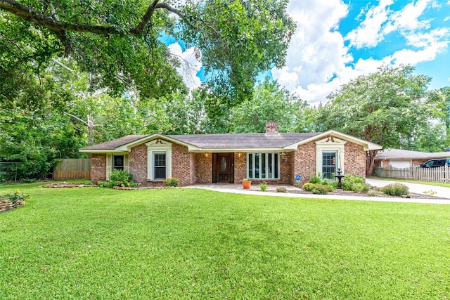 ranch-style house with brick siding, a chimney, a front yard, and fence