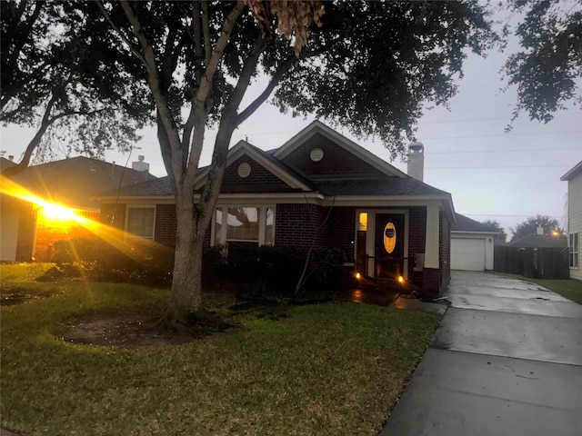 view of front of home with brick siding, a chimney, and a front yard