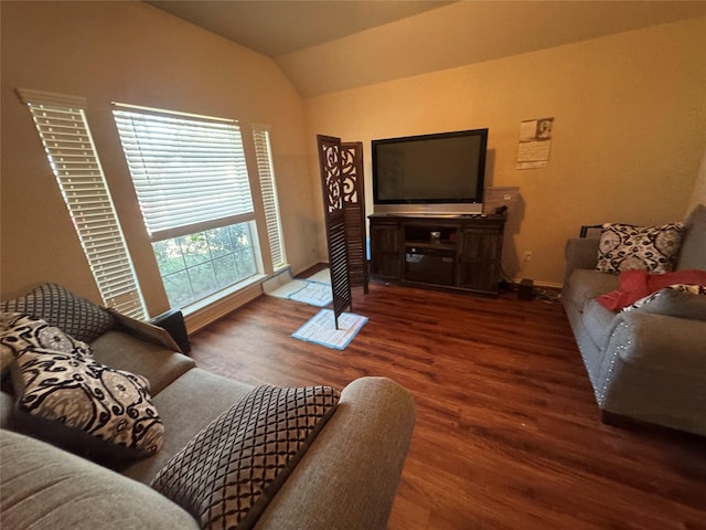 living room with dark wood-type flooring, vaulted ceiling, and baseboards