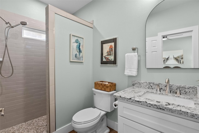 22318 Vista Del Mar, Galveston, TX 77554 - bathroom featuring vanity, baseboards, a tile shower, and toilet