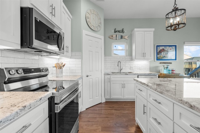 kitchen with white cabinetry, appliances with stainless steel finishes, dark wood finished floors, and a sink