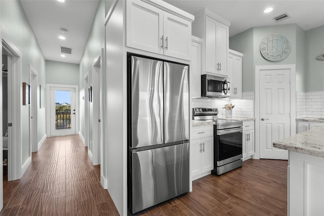 kitchen featuring tasteful backsplash, visible vents, white cabinets, dark wood-style floors, and appliances with stainless steel finishes