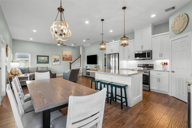 dining area with dark wood-type flooring, recessed lighting, visible vents, and a ceiling fan