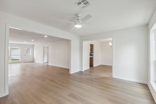 unfurnished room featuring ceiling fan, light wood-type flooring, visible vents, and baseboards