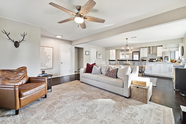 living room featuring ceiling fan with notable chandelier and wood finished floors