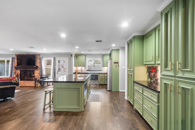 kitchen with dark countertops, a breakfast bar area, and green cabinetry