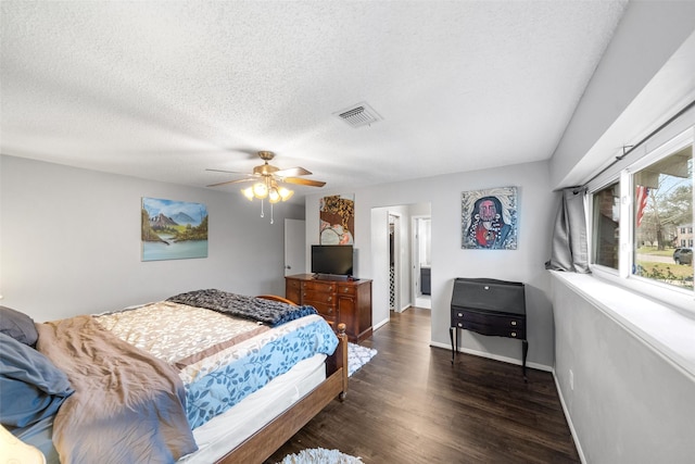 bedroom featuring a textured ceiling, dark wood finished floors, visible vents, and baseboards