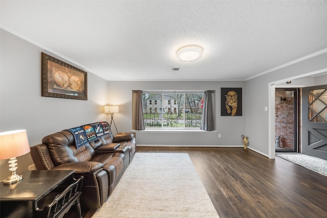 living room with a textured ceiling, dark wood-style flooring, visible vents, baseboards, and ornamental molding