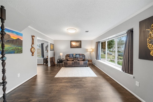 living area featuring dark wood-style floors, visible vents, ornamental molding, and baseboards