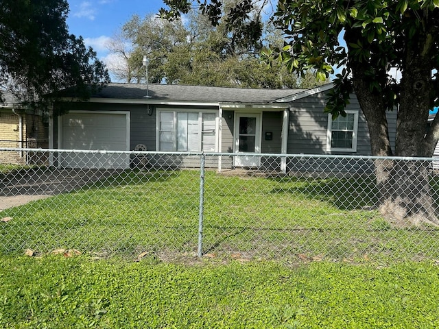 view of front facade with a fenced front yard, a front lawn, and an attached garage