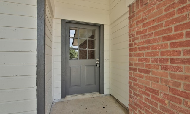 doorway to property featuring brick siding