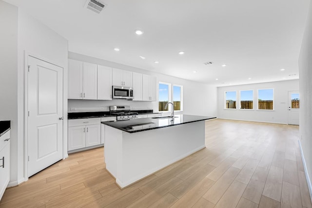 kitchen with dark countertops, visible vents, light wood finished floors, and stainless steel appliances