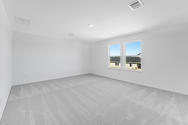 carpeted spare room featuring visible vents and baseboards