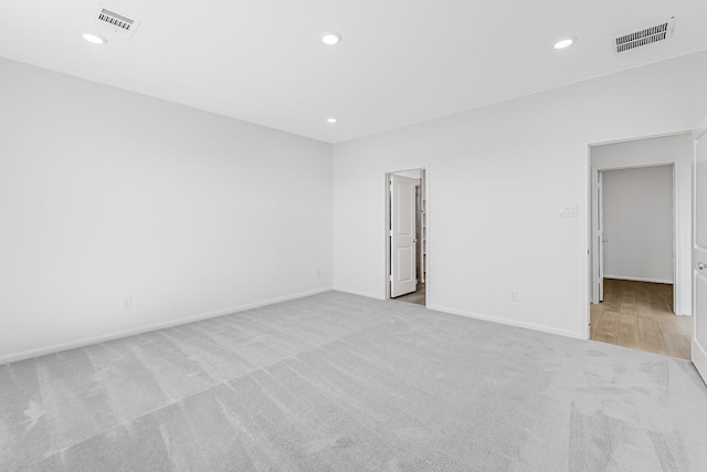 spare room featuring recessed lighting, visible vents, carpet floors, and baseboards